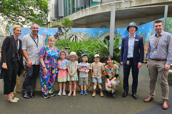 Members of Austin Health Executive team and staff smiling with children from Austin Childcare Centre